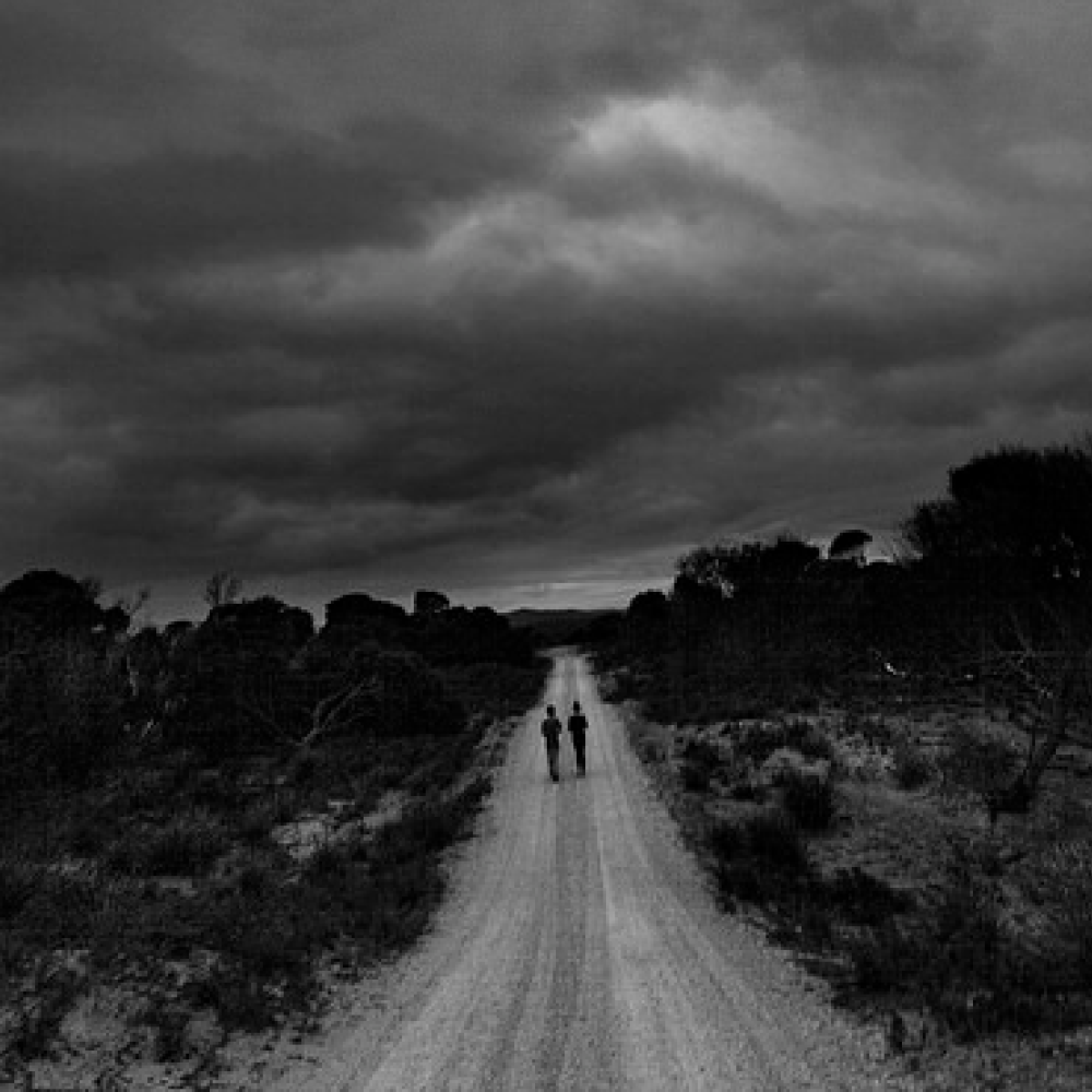 Two people walking odwn a long path