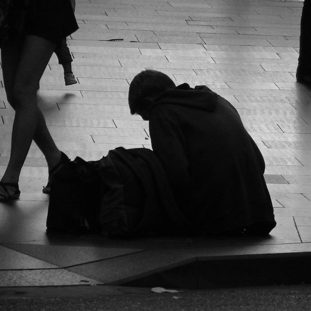 A homeless silhouette sitting between walkers