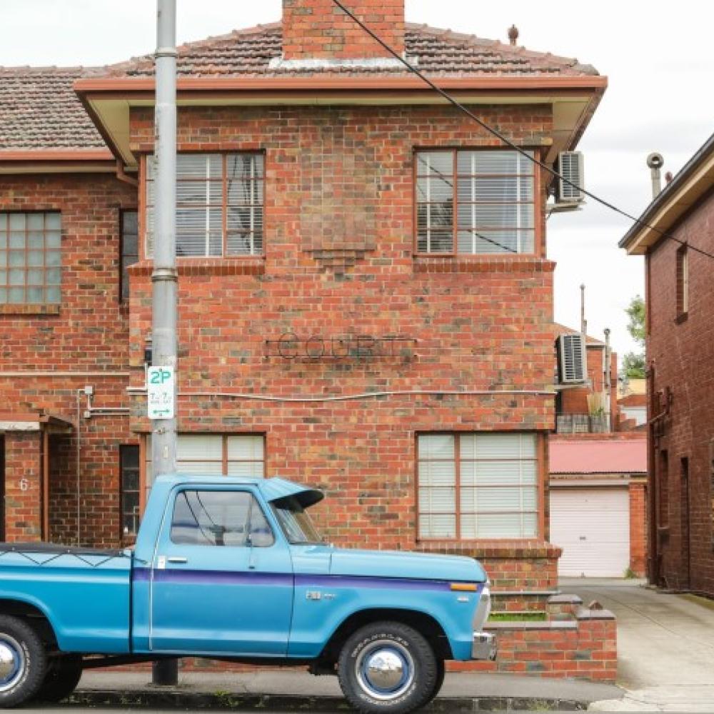 Blue Ute in front of a brick home